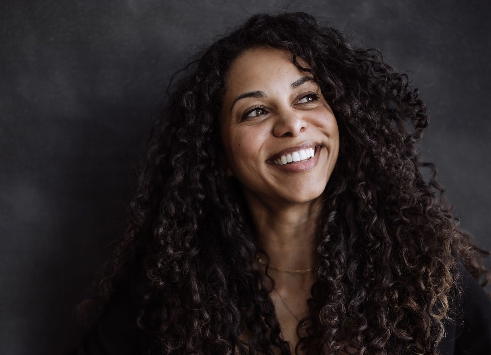 Soul-centered strategy—studio portrait of a confident woman in a black blazer, embodying values-led success.
